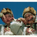 Altaian girls in national clothes playing komus (Jew's harp)